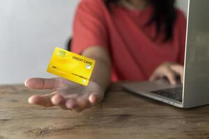 One hand holding credit card and another hand input order to computer laptop with shopping cart background. photo