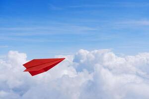 Paper red planes in blue sky. Sky background. The atmosphere is on the plane, sky is full of clouds floating around photo