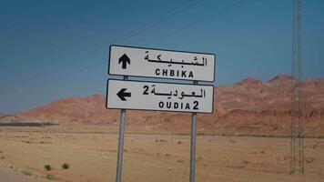 View of traffic sign in Oasis Chebika and desert valley on blue sky background. video