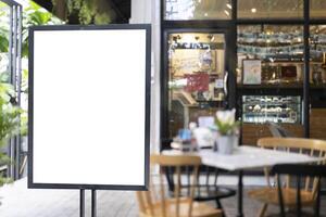 White blank signboard stand near the entrance to the coffee shop, mock up, cafeteria blurred background can inserting the text of the customer. photo