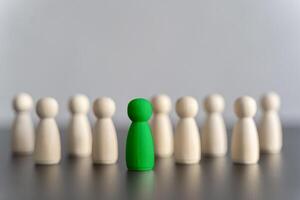 The green figure of a man comes out of the line of people. concept of success and improvement in work, the universal recognition of efficiency and leadership qualities. talent photo