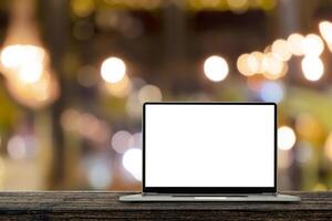 Desk Laptop with blank screen on table blur background with bokeh background photo
