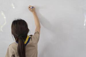 Close-up of a female teacher writing on a whiteboard in the classroom. photo