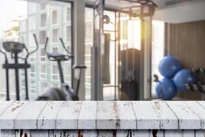 Table top and Blurred of fitness gym background for banner photo