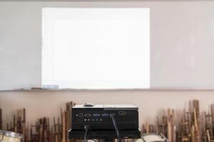 Projector in action with illuminated, teacher teaching schoolchildren using projector screen photo