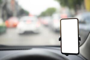 Modern smartphone device gadget mounted on phone holder at car dashboard. Mock-up white screen isolated template. Copyspace for text. photo