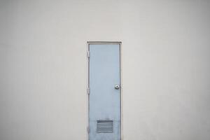 White closed door on white background. Frame on grey wall in the empty room. photo