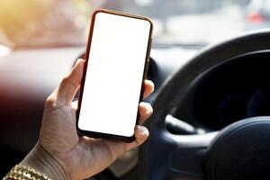 The driver uses the phone while driving. Modern smart phone with round edges. photo
