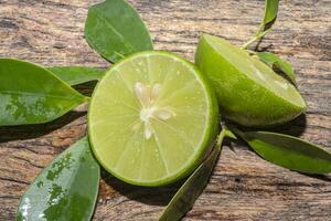 fresh ripe limes, lemon with green leafs photo