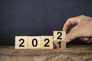 Hand changing Wooden Blocks With number 2021 to 2022 photo
