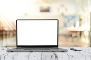 Notebook computer on the table with blank screen on classroom background photo