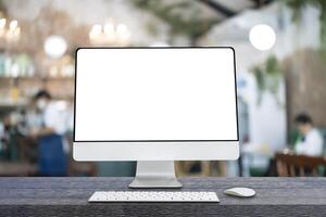 Computer monitor with white blank screen putting on wooden working desk photo