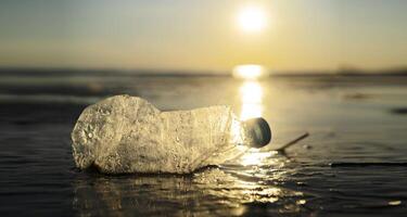 Concept of pollution, creative background. A plastic bottle floating in the ocean photo