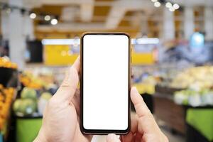 Mock-up of a smartphone with a white screen in the hands of a man. photo