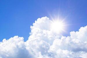 The sky is full of clouds floating around, the sun is shining brightly. photo