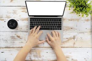 hand using and touching on laptop touchpad with blank white desktop screen photo