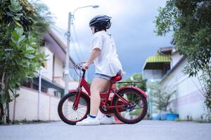 Children learning to drive a bicycle on a driveway outside. photo