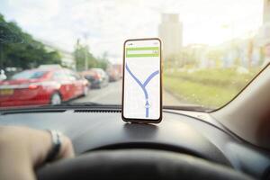 smartphone placed on the dashboard with a navigation map to help. photo