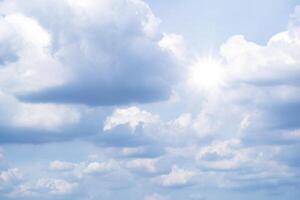 clouds floating around the houses, both small and large, the sun is shining brightly. photo