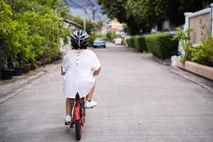 Children learning to drive a bicycle on a driveway outside. photo
