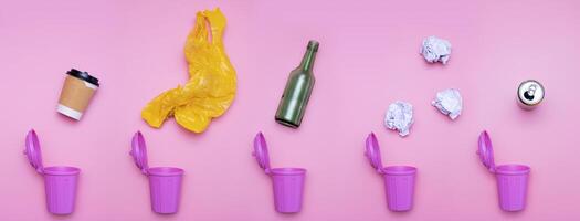 top view of trash bins and assorted garbage isolated on pink photo