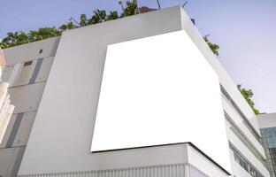 A large billboard installed in the corner of a large building. photo