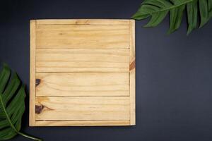 Top view of plank from dark wood, with frame from colorful autumn maple leaves. photo