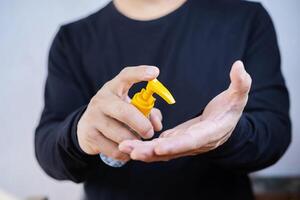 Antispetic sanitizer in hands. The man treats he hands with an antibacterial agent photo