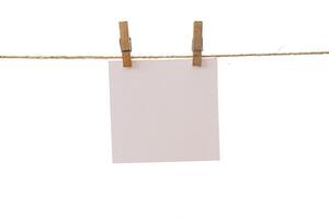 Empty color paper sheets for notes, frames that hang on a rope with clothespins and isolated on white photo