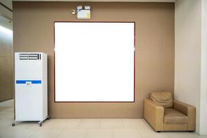 A blank billboard stuck on the wall with a sofa and air bubbles on the sides. photo