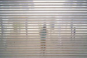 Steel garage roller shutter door, The surface is shiny, causing a reflection. Abstract stripe pattern background and texture photo