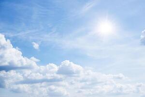 The sky is full of clouds floating around, both small and large, the sun is shining brightly photo