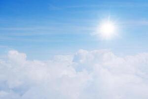 The sky is full of clouds floating around, both small and large, the sun is shining brightly. The atmosphere is on the plane. photo
