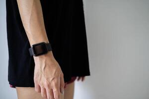 Cropped view of girl using smartwatch with blank screen on gray wall photo