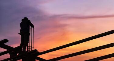 Silhouette of engineer and construction working at site over blurred background for industry background photo