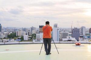 Take pictures using a tripod. Photographer intending to take pictures on the sky high rise building photo