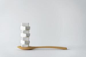 Spoon scoop sugar cubes Isolated on gray background, An empty space to insert ad text. photo