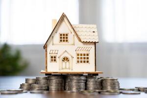 Mini house on stack of coins. Concept of Investment property. Concept for property ladder. photo