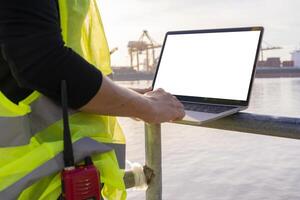 An engineer is using a tablet to work, she is at the shipping dock. Use radio communication for notifications and work orders. photo