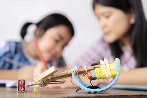 A teacher and an Asian female student build a motor vehicle in a science lesson photo