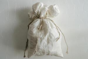 White fabric bag tied with string on neutral background photo
