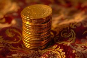 Golden coins stack on ornate fabric background photo
