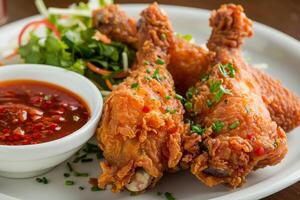 Crispy fried chicken with salad and chili sauce photo