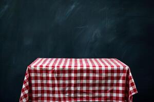 Red gingham tablecloth on empty table with chalkboard background photo