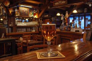 Glass of cold beer standing on countertop in empty bar at night photo