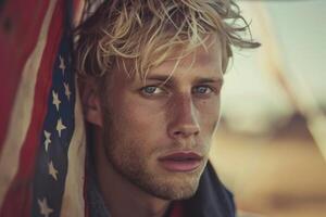 Blond man with blue eyes posing near american flag photo