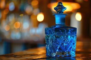 Blue crystal decanter standing on bar counter with bokeh background photo