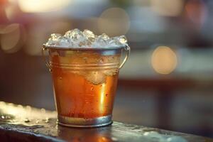 Cold beer with ice in metal bucket on blurred background photo