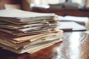 Stack of paperwork sitting on a desk in an office photo