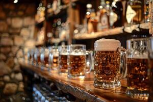Row of beer steins with a frothy head sitting on a bar photo